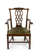 An antique Irish mahogany Chippendale armchair with finely carved scroll terminals to the arm rests, fretted back splat, cogwheel carving and shell decoration, 18th century, 100cm high, 68cm across the arms.