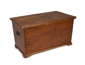 An antique Australian cedar blanket box of tapering sarcophagus form with exposed dovetail construction, with block feet and wrought iron carrying handles, 19th century, 52cm high, 93cm wide, 59cm deep.