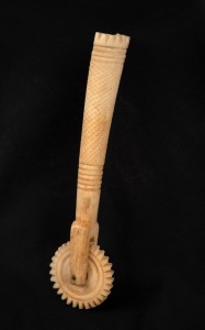 An antique carved bone jagging wheel pie crimper, 19th century, 16cm long.
