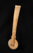 An antique carved bone jagging wheel pie crimper, 19th century, 16cm long.