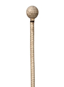 An antique shark vertebrae walking stick with scrimshaw whale's tooth top with tallship decoration engraved "L.F. 1842", 19th century, 85cm high.