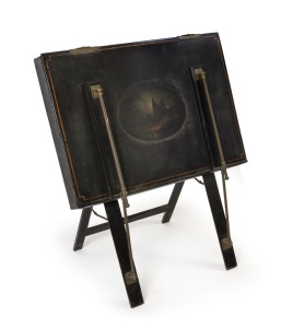 An antique folio stand, black lacquered finish and pictorial vignette, 19th century, 103cm high, 81cm wide.
