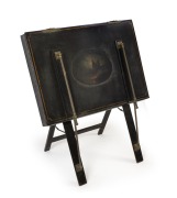 An antique folio stand, black lacquered finish and pictorial vignette, 19th century, 103cm high, 81cm wide.