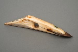 An Inuit harpoon tip, carved walrus tooth and steel, 13cm long.
