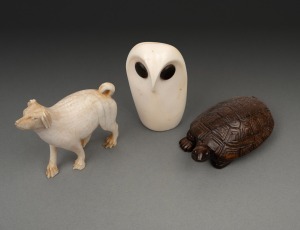 A vintage Japanese carved boxwood turtle netsuke, an Inuit carved marine ivory owl figure, and a carved ivory dog figure, 20th century, (3 items), 5.5cm high.