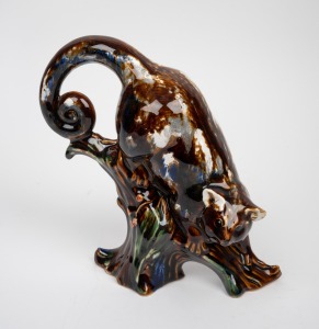 HUNTLY pottery ringtail possum statue with mottled glaze, factory mark to base, 23cm high.