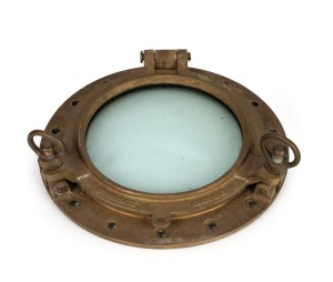 An impressive cast brass porthole with hinge opening, dual spindle locks and original armour plate glass, circa 1940, the glass 30cm diameter, 49cm diameter overall.