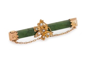 An antique New Zealand greenstone and gold mounted bar brooch with butterfly decoration, adorned with seed pearls, 19th century, 5.3cm wide.