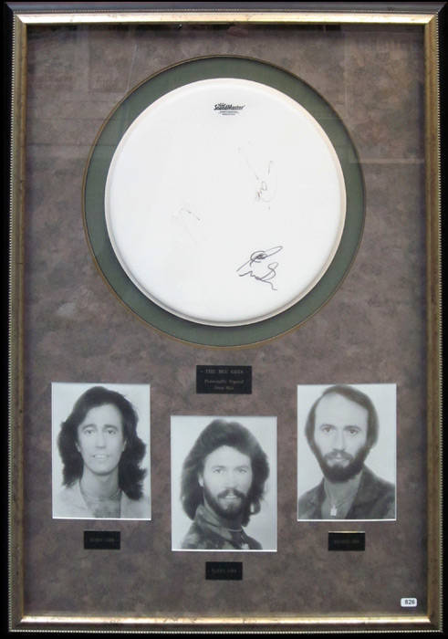 BEE GEES, display comprising drum skin signed by Barry Gibb, Robin Gibb & Maurice Gibb (two signatures faded), window mounted with photographs of the three brothers, framed & glazed, overall 75x103cm. With CoA.