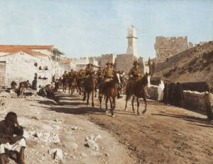 HURLEY, Frank (Australian, 1885-1962), AUSTRALIANS OF THE ANZAC MOUNTED DIVISION PASSING THROUGH JERUSALEM 1918, hand coloured silver gelatin photograph, publishing annotations in pencil in an unknown hand verso, 31x38cm. Shows Major Donald Gordon Cross o