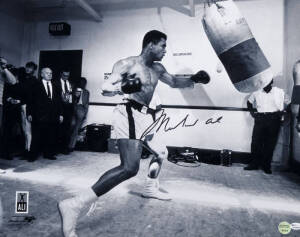 MUHAMMAD ALI, signed photograph of Muhammad Ali with punching bag, size 51x40cm. With 'Online Authentics' No.9669.