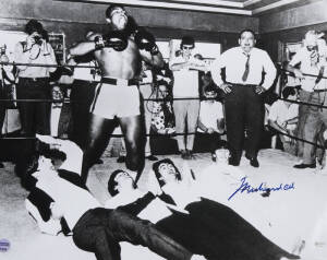 MUHAMMAD ALI & THE BEATLES, photograph of Ali standing over The Beatles, signed "Muhammad Ali", size 51x40cm. With 'Online Authentics' No.7220.