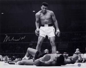 MUHAMMAD ALI, signed b/w photograph of Ali standing over Sonny Liston, size 51x41cm. With 'Online Authentics' No.OA-8090300.