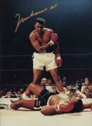 MUHAMMAD ALI, signed colour photograph of Ali standing over Sonny Liston, size 28x35cm. With CoA No.0453.