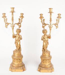 An impressive pair of gilt composite wood three-branch candelabras with central putti on stand, 20th century. 118cm