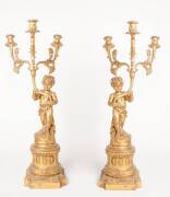 An impressive pair of gilt composite wood three-branch candelabras with central putti on stand, 20th century. 118cm