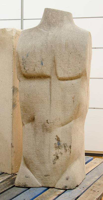 A large carved sandstone torso of a male