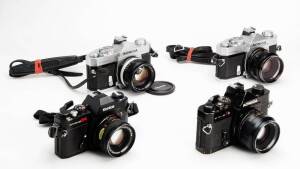 KONISHIROKU KOGAKU (Japan): Konica Autoreflex T- series 35mm SLR cameras (5). Consisting of: A Konica Autoreflex T with AR 50mm f1.4, lens cap, camera strap, body- and rear lens cap and camera manual in original box. A second Autoreflex T with 57mm f1.4, 