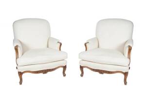 Pair of French Louis XV style 19th century large bergeres with carved oak frames upholstered in cream fabric.