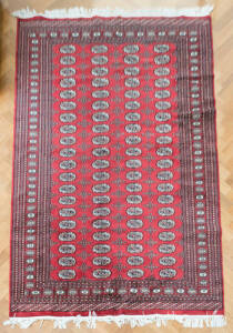 RUG: Black & red handwoven rug, Pakistan origin. 245 x 155cm