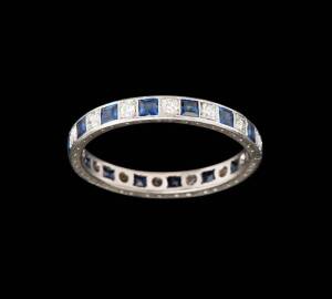 A diamond and synthetic sapphire eternity band. White gold.