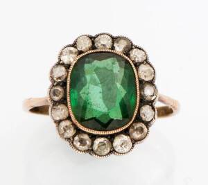 A tourmaline and diamond cluster ring. The oval green tourmaline surrounded by old cut diamonds. 18ct yellow gold. Size S1/2.