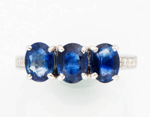 A sapphire and diamond dress ring. Set across with three oval sapphires T.C.W 2.24ct and diamond set shoulders. 18k white gold.&nbsp;