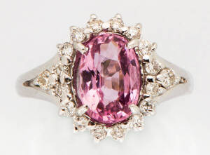 A spinel and diamond cluster ring. The oval pink spinel T.C.W 2.06ct surrounded by small brilliant diamonds T.C.W .28ct. 18k white gold