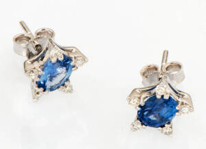 A pair of sapphire and diamond cluster earrings. The oval sapphires T.C.W. 2.08ct set around with small brilliant diamonds T.C.W. 25ct. 18k white gold.