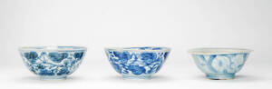 Three Chinese blue and white Ming Dynasty bowls, each one decorated with flowers, two with four character marks, 17 to 18cm diameter