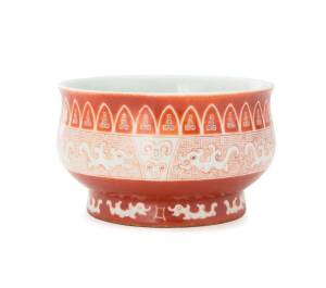 A Chinese iron red decorated bowl, 20th century, six character Ming mark to base, four character mark in the centre, on wooden stand. 9.5cm high, 16cm diameter