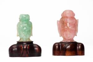 Two Chinese hard stones heads of Guanyin, early 20th century, one pink quartz, one green quartz, with fitted wooden bases, 11cm high and 10.5cm high without stands