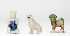 Three small Chinese figures, Qing Dynasty, 18th century, comprising a blue and white seated boy, a seated hound and a buddhist lion, 6.5 to 8cm high