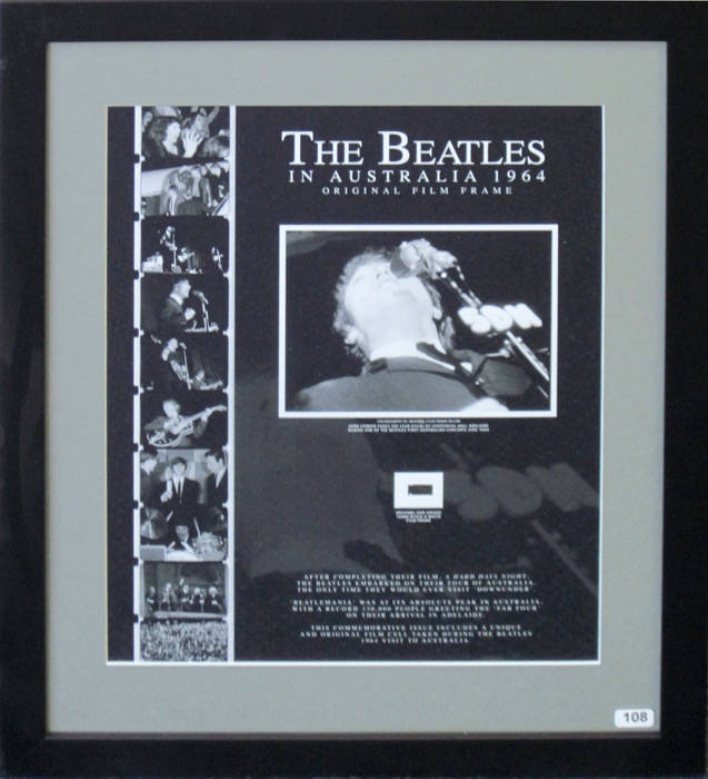 THE BEATLES IN AUSTRALIA 1964 - ORIGINAL FILM FRAME: Display with original 16mm film frame, with enlarged print of image, "John Lennon takes the lead vocal at Centennial Hall Adelaide during one of The Beatles first Australian concerts June 1964", window