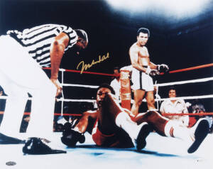 MUHAMMAD ALI, signed colour photograph of Ali standing over George Foreman, size 51x41cm.
