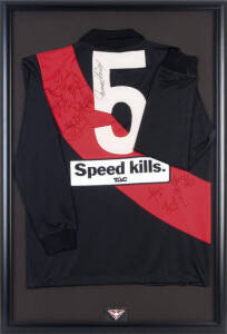 ESSENDON: Essendon football jumper (with no."5" on reverse) with 9 signatures including James Hird, Kevin Sheedy & Michael Long, window mounted, framed & glazed, overall 66x97cm.