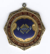 MUIR WILSON CHALLENGE SHIELD, 9ct gold & enamel medal with "MW/1896" & engraved "T.J.Gascoyne" on front, with on reverse "Presented to the Winner of the Muir Wilson Challenge Shield". Very attractive. Weight 18.82 grams.