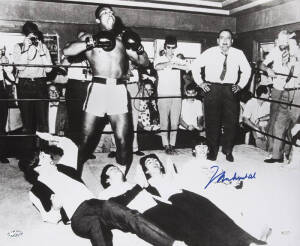 MUHAMMAD ALI & THE BEATLES, photograph of Ali standing over The Beatles, signed "Muhammad Ali", size 51x40cm. With 'Online Authentics' No.12476.