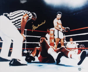 MUHAMMAD ALI, signed colour photograph of Ali standing over George Foreman, size 51x41cm. With 'Online Authentics' No.9681.