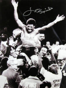 LEON SPINKS, signed b/w photograph of Spinks celebrating his victory over Muhammad Ali, size 30x41cm.