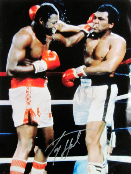 LARRY HOLMES, signed colour photograph of his fight v Muhammad Ali, size 30x41cm.