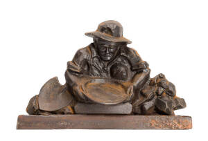 A cast iron door stop moulded with the figure of a miner, height 20cm, width 31cm.