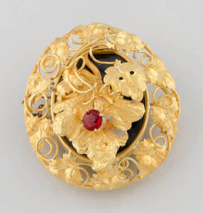 A gold foliate locket brooch, circa 1870, the hinged front section set with a garnet topped doublet, length 5cm, width 4.5cm.