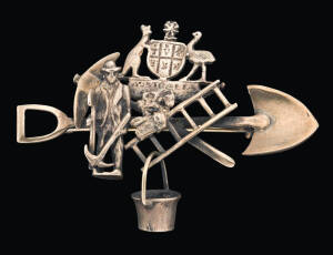 A gold figurative miner's brooch, marked 9ct.