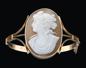 A gold helmet shell cameo bangle, G.H. Palfrey, Melbourne, inscribed Olive from Steve 22.1.14, marked 15ct.