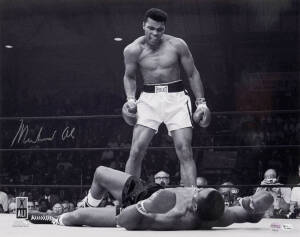 MUHAMMAD ALI, signed b/w photograph of Ali standing over Sonny Liston, size 51x41cm. With 'Online Authentics' No.OA-8090302.