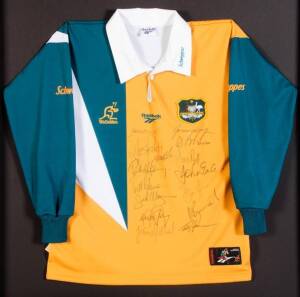 c1996 WALLABIES: Wallabies jersey with 15 signatures including Jason Little, Andrew Heath & Matt Burke, window mounted, framed (no glass), overall 94x94cm. Plus framed Rugby Union action photograph.