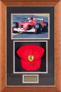 MICHAEL SCHUMACHER, display comprising signed Ferrari cap, window mounted with action photograph, framed & glazed, overall 50x76cm. With CoA.