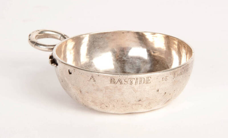 A silver wine taster (tastevin) with serpent handle, French, 19th century. 8cm diameter.