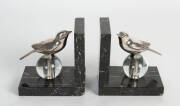 A pair of art deco silver plated, black and gey marble with glass bird form bookends, French, 1925. Stamped BPONZE. Each 14cm high, 12.5cm wide, 8cm deep.